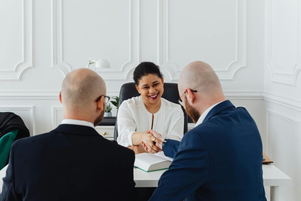 three-people-shaking-hands-at-a-table
